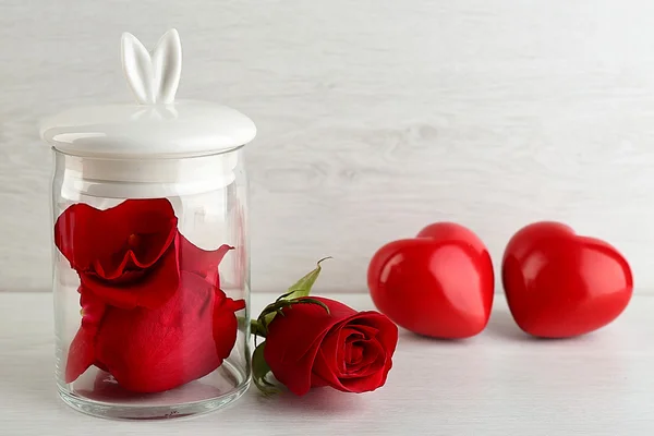 Rose flower in glass jar on light background — Stock Photo, Image