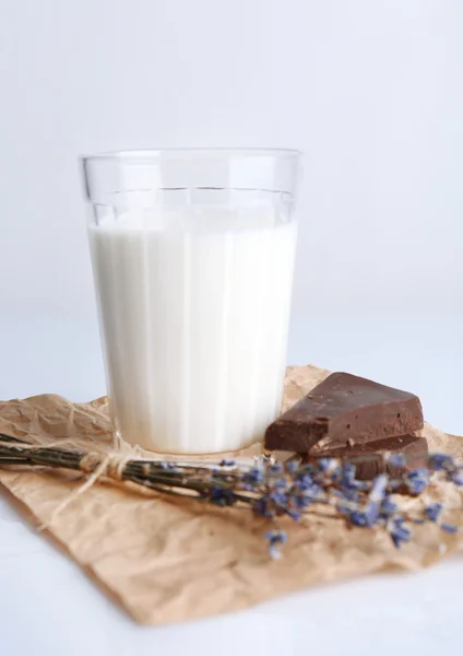 Bicchiere di latte con pezzi di cioccolato su foglio di carta spiegazzata isolato su bianco — Foto Stock