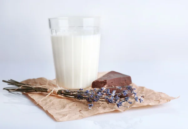 Glas melk met chocolade stukjes op vel verfrommeld papier geïsoleerd op wit — Stockfoto