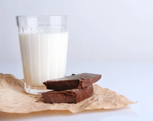 Vaso de leche con trozos de chocolate en hoja de papel arrugado aislado en blanco — Foto de Stock