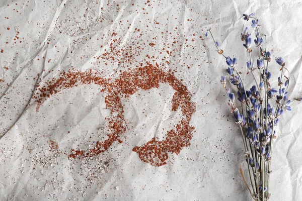 Traces of cocoa and sugar with dried flowers on crumpled sheet of paper background