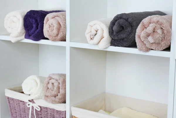 Walcowane ręczniki z wikliny kosz na półce w szafie tła — Zdjęcie stockowe