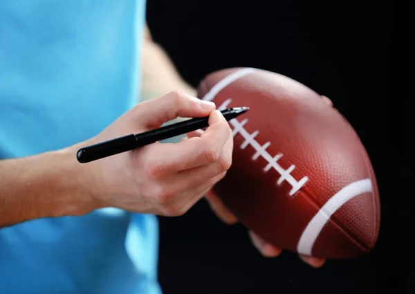 American football star signing autograph