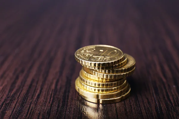 Pilha de moedas de ouro no fundo da mesa de madeira — Fotografia de Stock