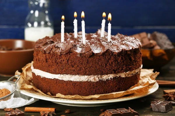 Delicious chocolate cake on table on blue background — Stock Photo, Image