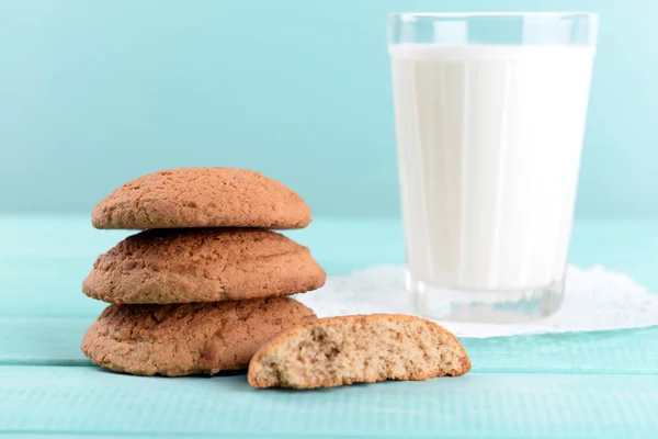 Tasty cookies and glass of milk on color wooden background — Stock Photo, Image