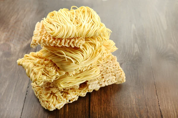 Diverse tagliatelle istantanee asciutte su sfondo di legno — Foto Stock