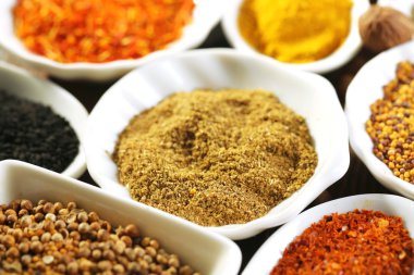 Seramik baharat çeşitleri kaşıklar, yakın çekim, ahşap arka plan üzerinde