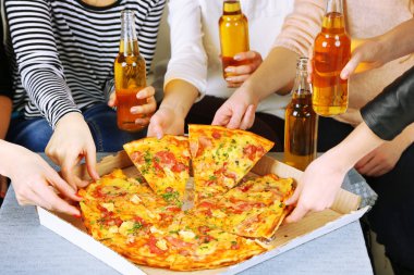 Arkadaşlar el ile şişe bira ve pizza, yakın çekim