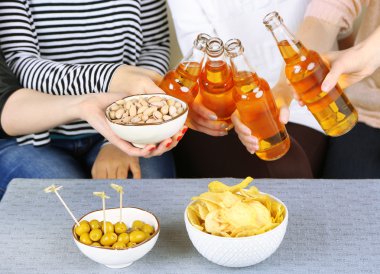 Arkadaşlar el ile şişe bira ve aperatifler, yakın çekim