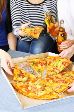 Arkadaşlar el ile şişe bira ve pizza, yakın çekim
