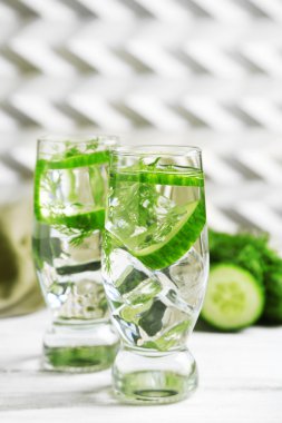 Gözlük ile taze organik salatalık suyu üzerinde açık renkli ahşap tablo