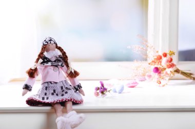 Pencere yakınındaki el yapımı oyuncak bebek