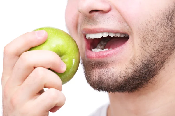 Homem mordendo maçã verde fresca com dentes saudáveis isolados no fundo branco — Fotografia de Stock