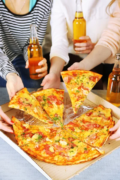 Друзі руки з пляшками пива і піци, крупним планом — стокове фото