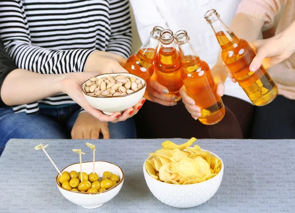 Friends hands with bottles of beer and snacks, close up — Stock Photo, Image