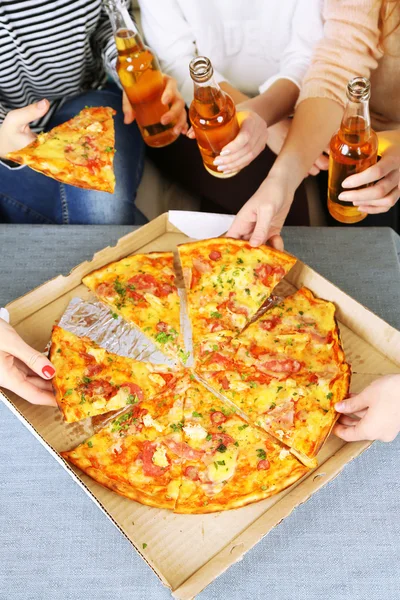 Amis mains avec des bouteilles de bière et de pizza, gros plan — Photo