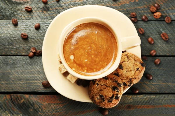 Filiżankę kawy i smaczne ciasteczka, na drewnianych tło — Zdjęcie stockowe