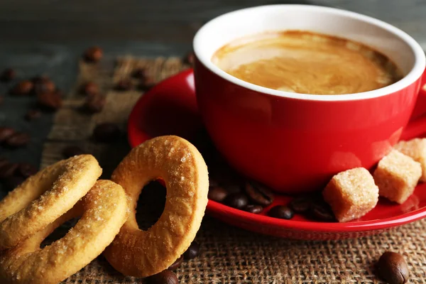 Fincan kahve ve ahşap arka plan üzerinde çul peçete lezzetli kurabiyeleri — Stok fotoğraf