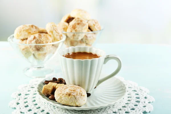 Cup of coffee and tasty cookies on color wooden table, on light background — Stock Photo, Image
