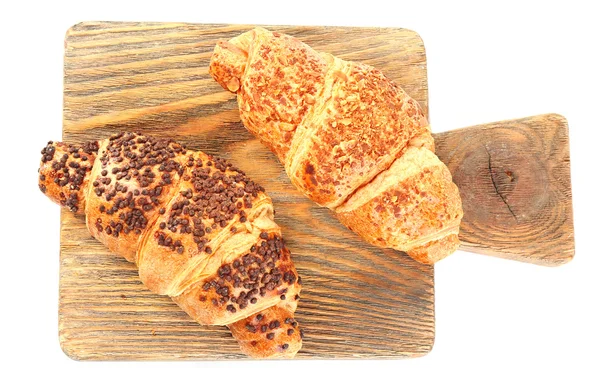 Färska och läckra croissanter med choklad på träplatta, isolerad på vit — Stockfoto