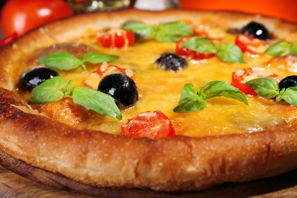 Pizza com queijo e legumes em tábua de madeira e fundo colorido escuro — Fotografia de Stock