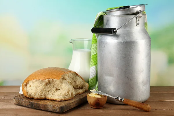 Retro pode para leite com pão fresco e jarro de leite na mesa de madeira, no fundo brilhante. Conceito de produtos biológicos — Fotografia de Stock