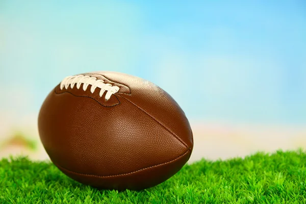 Football americano sul campo su erba verde, su sfondo cielo blu — Foto Stock