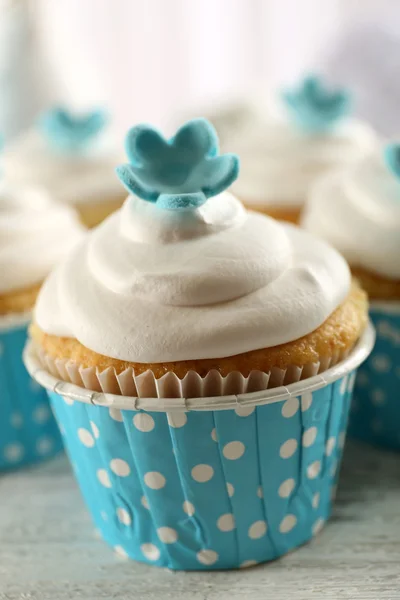 Deliciosos cupcakes en la mesa sobre fondo claro — Foto de Stock