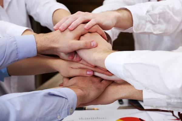 United hands of business team on workspace background