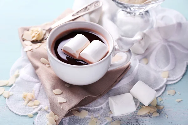 Cioccolata calda con marshmallow in tazza, su sfondo di legno a colori — Foto Stock