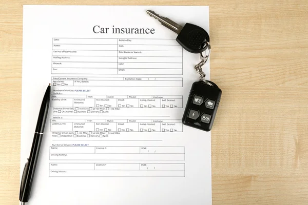 Car keys on insurance documents, close up — Stock Photo, Image