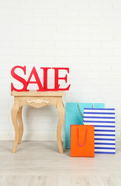 Sale with bags on side table in room — Stock Photo, Image