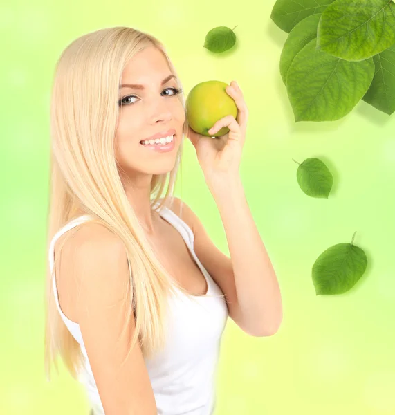 Όμορφη νεαρή γυναίκα με το πράσινο μήλο σε φυσική φόντο — Φωτογραφία Αρχείου
