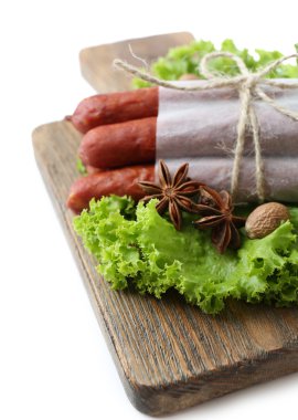 marul salata yaprakları ve baharat üzerine beyaz izole, ahşap kesme tahtası üzerinde ince Sosis füme