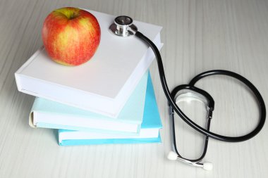 Ahşap masa kitap üzerinde apple ile sağlık stetoskop