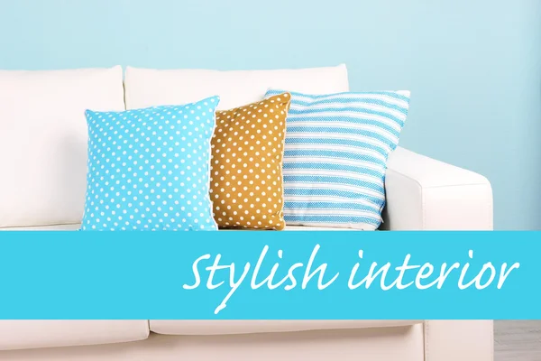 Biała kanapa z kolorowe poduszki na ścianie tle, stylowe wnętrza koncepcja — Zdjęcie stockowe