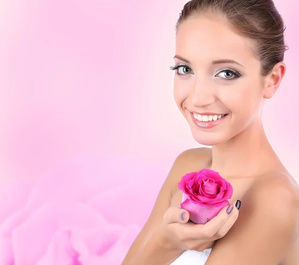 Beautiful young woman holding pink rose on bright pink background — Stock Photo, Image