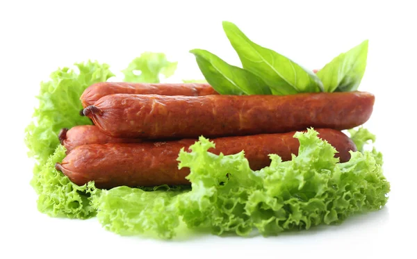 Smoked thin sausages  with lettuce salad leaves, isolated on white — Stock Photo, Image