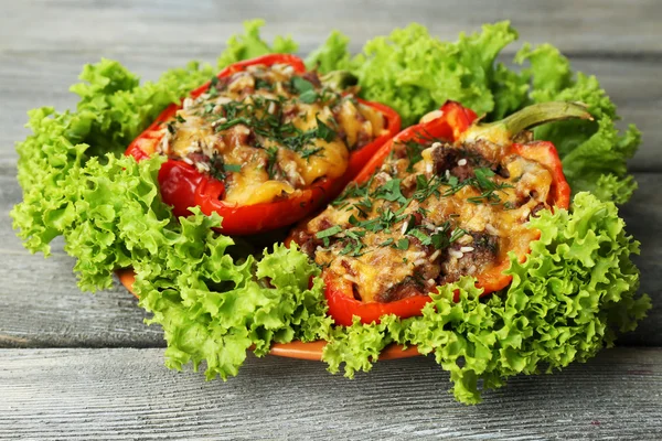 Gefüllte rote Paprika mit Gemüse auf Teller auf Holztisch — Stockfoto