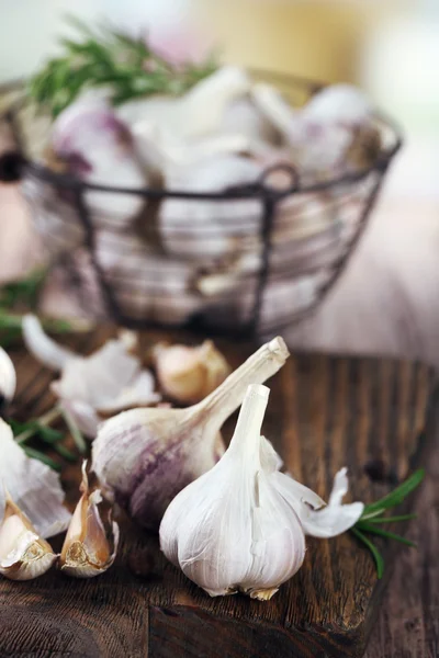 Rauwe knoflook en kruiden op houten tafel — Stockfoto