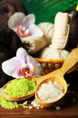 Spa uygulamaları ile renkli arka plan üzerinde ahşap masaya orkide çiçek