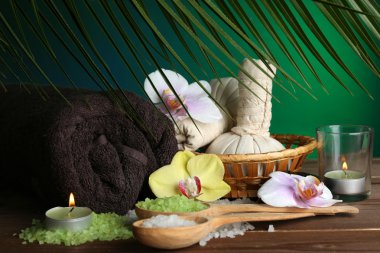 Spa uygulamaları ile renkli arka plan üzerinde ahşap masaya orkide çiçek