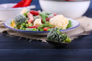 Dondurulmuş sebze peçeteye ahşap masa arka plan üzerinde plaka üzerinde