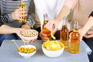 Arkadaşlar el ile şişe bira ve aperatifler, yakın çekim