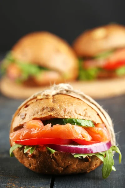 Sandwiches with salmon and vegetables on wooden background — Stock Photo, Image