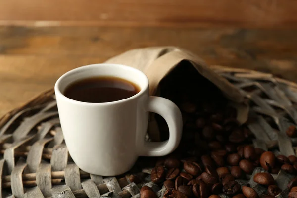 Cup of coffee with beans on rustic wooden background — Stock Photo, Image