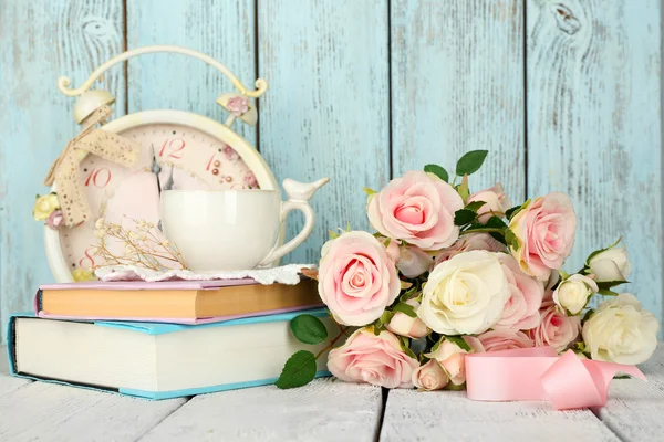 Taza de té con libros y flores sobre fondo de madera — Foto de Stock