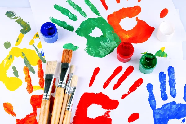 Hand prints of paint, paints and brushes on white background — Stock Photo, Image