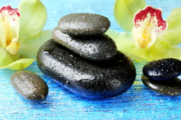 Spa stones with water drops and beautiful blooming orchid close-up — Stock Photo, Image